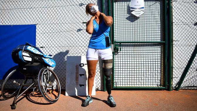 Atlet para tenis Prancis Pauline Deroulede melakukan strech sebelum pertandingan selama edisi ke-4 turnamen tenis kursi roda French Riviera Open di Biot, 28 September 2020. Pauline Deroulede saat ini tengah fokus terhadap Paralimpiade Paris 2024. (FRANCK FIFE/AFP)