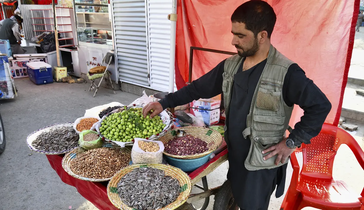 Dalam gambar yang diambil pada 5 April 2022, seorang penjual makanan ringan menunggu pelanggan di pasar selama bulan suci Ramadhan di Kabul, Afghanistan. (Sahel ARMAN / AFP)