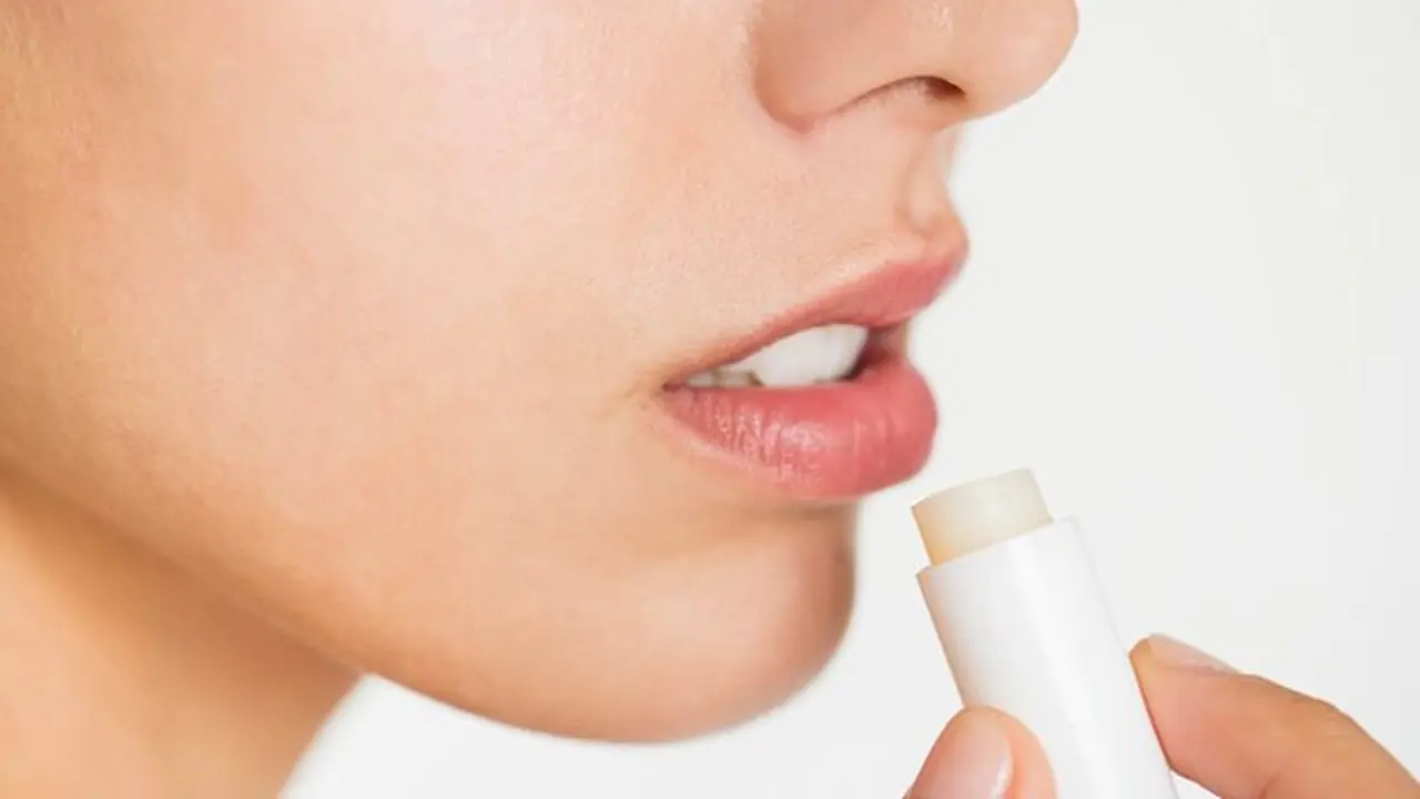 Seorang perempuan menggunakan produk lip balm untuk merawat bibirnya (Foto Dok: Freepik/rawpixel.com)