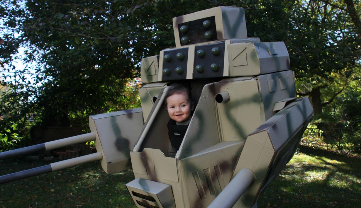 Bocah bernama Geraint tampak tersenyum saat ia bersama ayahnya memakai kostum Halloween yang diberi judul MechWarrior Halloween (Imgur.com)