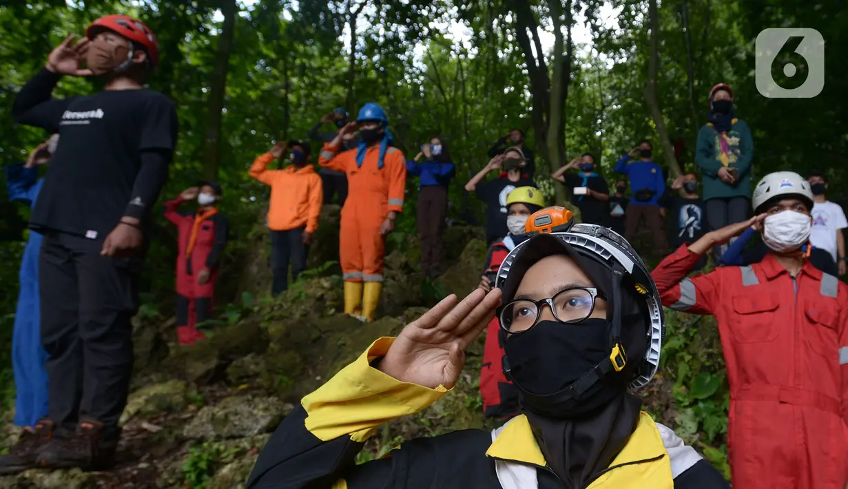 Jaringan Masyarakat Peduli Karst Klapanunggal membentangkan bendera merah putih dalam rangka peringatan HUT ke-75 RI di Tebing Kutalingkung, Klapa Nunggal, Jawa Barat, Senin (17/8/2020). Sebanyak 80 orang mengikuti pengibaran bendera berukuran 15 meter x 10 meter tersebut. (merdeka.com/Imam Buhori)