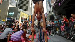 Warga berpose ketika melakukan gerakan yoga di tengah jalan saat perayaan Summer Solstice di Hari Yoga Internasional di Times Square, New York, Minggu (21/6/2015). (REUTERS/Eduardo Munoz)