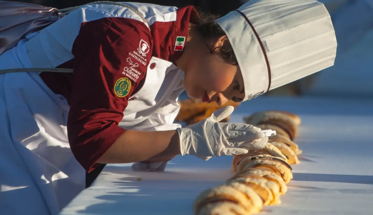 Suasana pembuatan kue raja sepanjang 2.063,43 meter di Saltillo, Negara Bagian Coahuila, Meksiko, 6 Januari 2019. Kue yang dibuat adalah brioche berukuran besar, yang dikenal sebagai "Rosca de Reyes" atau cincin raja. (Julio Cesar AGUILAR/AFP)