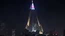Pertunjukan cahaya menampilkan bendera Korea Utara di atas hotel Ryugyong di kota Pyongyang, Korea Utara (9/4). (AFP Photo/Ed Jones)