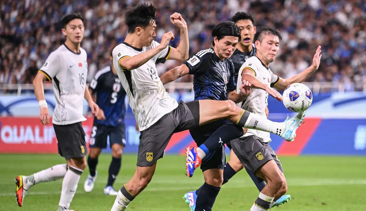 Pemain Jepang, Takumi Minamino (tengah) berebut bola dengan sejumlah pemain China pada laga putaran ketiga Grup C Kualifikasi Piala Dunia 2026 yang berlangsung di Saitama Stadium, Saitama, Jepang, Kamis (05/09/2024) WIB. (AFP/Yuichi Yamazaki)