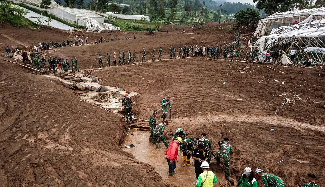 Dalam keterangan resminya, Kepala Pusat Data, Informasi dan Komunikasi Kebencanaan Badan Nasional Penanggulangan Bencana (BNPB), Abdul Muhari mengatakan hingga Senin (26/1/2026) pukul 18.30 WIB, tim SAR gabungan telah mengevakuasi dan mengirimkan total 38 kantong jenazah ke pos DVI untuk proses identifikasi lebih lanjut. Tampak dalam foto, tim penyelamat mencari korban tanah longsor di Desa Pasirlangu, Cisarua, Kabupaten Bandung, Jawa Barat pada 25 Januari 2026. (Timur Matahari/AFP)