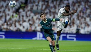 Bek Real Madrid asal Jerman bernomor punggung 22, Antonio Ruediger (kanan), menendang bola melewati gelandang Manchester City asal Portugal bernomor punggung 20, Bernardo Silva, selama pertandingan pekan ke-6 Phase League Liga Champions antara Real Madrid CF dan Manchester City di Stadion Santiago Bernabeu di Madrid, Kamis (11-12-2025) dini hari WIB. (Oscar DEL POZO/AFP)