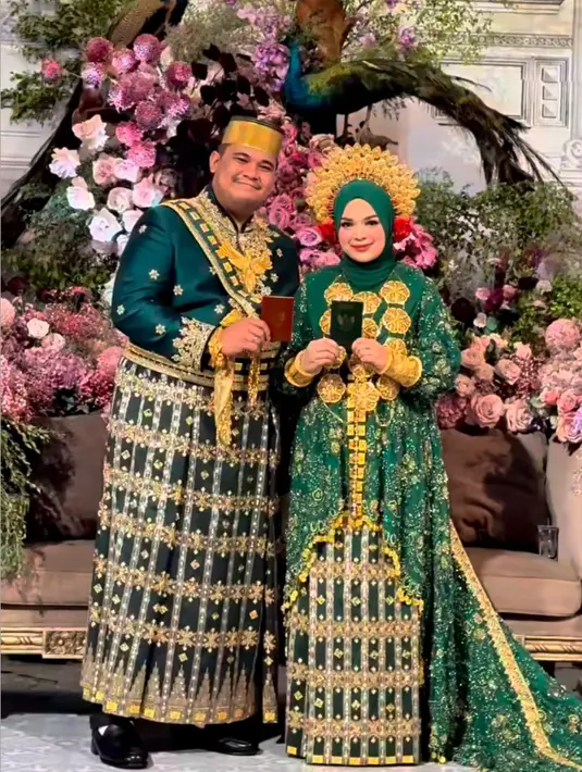 Baju pengantin hijau tersebut dibuat oleh Svarna By Ikat Indonesia. Sang mempelai wanita semakin mewah dengan aksesori kalung emas besar dan gelangnya. [@thepotomoto]