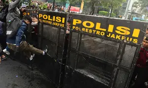 Salah satu pengunjuk rasa mencoba membuka blokade aparat keamanan saat berunjuk rasa di kawasan jalan Jenderal Sudirman, Jakarta, Jumat (12/6/2026). (merdeka.com/Arie Basuki)