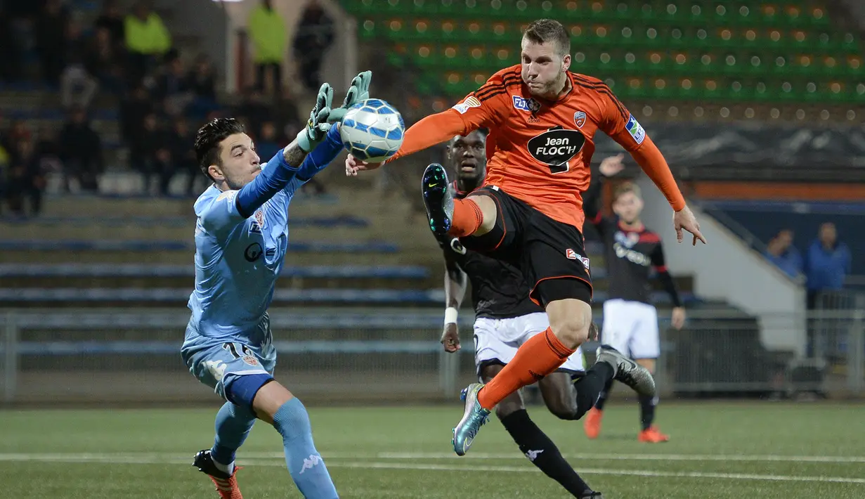 Kiper Dijon Perancis, Enzo Basilio (kiri) berusaha menghalau bola dari Penyerang Lorient Perancis, Valentin Lavigne saat laga Piala Liga pada 15 Desember 2015 di Stadion Moustoir di Lorient, Prancis. (AFP Photo/Jean Sebastian Evrard)