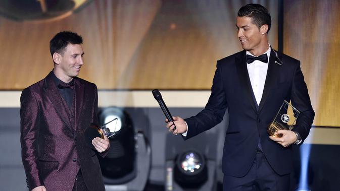 Cristiano Ronaldo memberikan microphone kepada Lionel Messi saat acara penghargaan Ballon d'Or di Zurich, (12/1/2015). (AFP/Fabrice Coffrini)