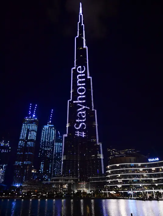 Pencakar langit Burj Khalifa menyala dengan pesan "Stay Home" di Dubai pada Selasa (24/3/2020). Gedung pencakar langit tertinggi di dunia itu menyala dengan slogan kampanye #STAYHOME yang mendesak warga untuk mematuhi langkah-langkah pencegahan di tengah pandemi COVID-19. (Giuseppe CACACE/AFP)