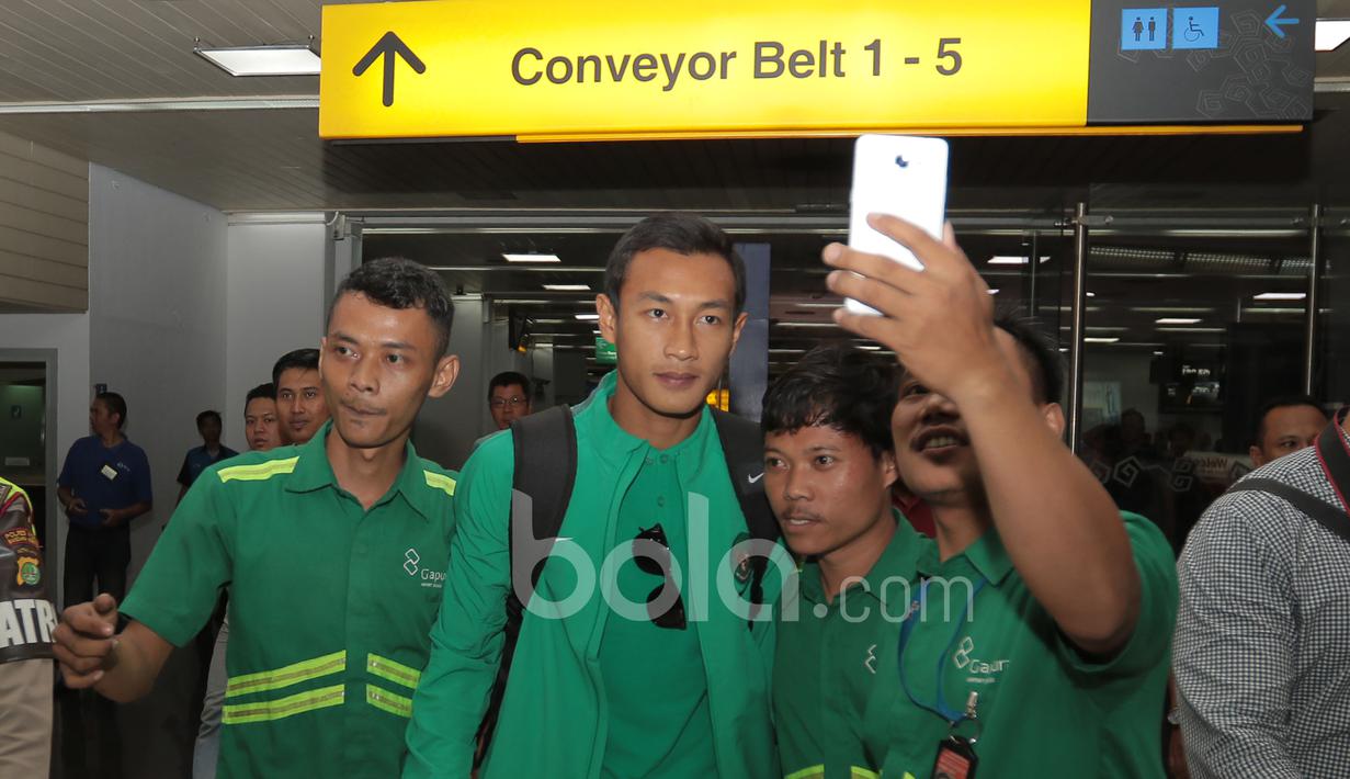 Fans berfoto selfie bersama Hansamu Yama saat Timnas Indonesia tiba dari Thailand di Bandara Soekarno-Hatta, Cengkareng, (18/12/2016). (Bola.com/Nicklas Hanoatubun)