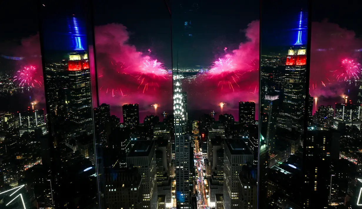 <p>Kembang api meledak di atas East River selama pertunjukan tahunan ke-47 Macy's 4th of July Fireworks dengan Empire State Building tercermin dari Summit One Vanderbilt di New York City, Amerika Serikat, Selasa (4/7/2023). Pesta kembang api memeriahkan Hari Kemerdekaan Amerika Serikat. (Alexi J. Rosenfeld/Getty Images/AFP)</p>