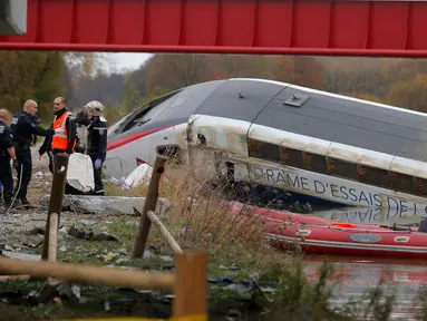 Petugas saat melakukan evakuasi terhadapa kereta yang tergelincir dan jatuh disebuah sungai dekat Strasbourg, Perancis, Sabtu (14/11/2015). Diduga kereta tergelincir karena menggunakan kecepatan yang berlebihan. (REUTERS/Vincent Kessler)