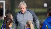 PM Inggris Boris Johnson berbincang dengan anak-anak sebelum pertandingan sepak bola putri junior antara Hazel Grove United JFC dan Poynton di Cheadle Hulme, Inggris, Sabtu (7/12/2019). Aksi itu dalam rangka kampanye jelang pemilu Inggris pada 12 Desember 2019. (Toby Melville/Pool Photo via AP)