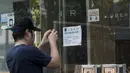 Seorang pria mengambil gambar di luar kantor jasa pelayanan taxi Uber Inc usai polisi Hong Kong melakukan razia dan mengamankan 5 orang sopir, Selasa (11/8/2015). (REUTERS/Apple Daily)