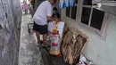 Seorang pria menyiapkan sampah rumah tangga anorganik, berupa kardus dan botol plastik, untuk disetorkan ke bank sampah setempat, Jakarta, Kamis 4 Juni 2026, sebagai bagian dari instruksi Pemprov DKI yang mewajibkan warga memilih dan memilah sampah untuk mengurangi beban sampah yang semakin menumpuk di ibu kota. (BAY ISMOYO/AFP)