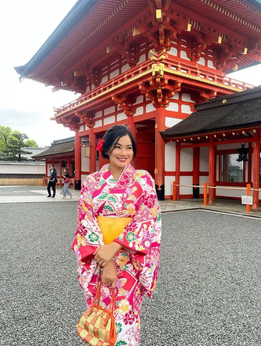 Titi Kamal tampil dengan kimono merah ketika berlibur ke Jepang. Titi Kamal tampil cantik dengan kimono merah dan obi kuning. [Foto: Instagram/titi_kamall]