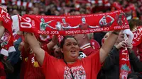 Seorang penggemar Liverpool mengangkat syal yang didedikasikan untuk mendiang Diogo Jota, menjelang pertandingan persahabatan pramusim pertama antara Liverpool dan Athletic Bilbao di Anfield, Liverpool, Senin (4/8/ 2025) dini hari WIB. (Darren Staples / AFP)
