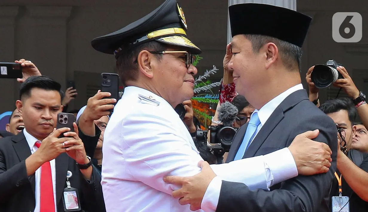 Gubernur Daerah Khusus Jakarta, Pramono Anung (kiri) memeluk Penjabat Gubernur Jakarta Teguh Setyabudi sesaat sebelum melakukan serah terima jabatan dengan di Balai Kota, Kamis (20/2/2025). (Liputan6.com/Herman Zakharia)