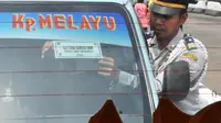 Petugas memasang stiker barcode uji coba pembatasan BBM bersubsidi pada angkutan umum jurusan Senen - Kampung Melayu di Terminal Senen, Jakarta, Rabu (23/2). (Antara)