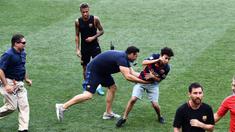 Petugas menangkap fans yang masuk ke lapangan mengejar pemain Barcelona, Lionel Messi dan Neymar saat latihan di Red Bull Arena, New Jersey, Jumat (21/7/2017). Latihan ini dilakukan jelang laga ICC 2017 melawan Juventus. (AFP/Jewel Samad)