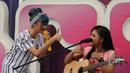 Salah satu personel The Virgin, Dara (kiri) mengacungkan jempol usai berduet dengan Alif Ekacahya (pemenang keempat ajang Music Vidio Contest di panggung inBox SCTV di Cibinong, Bogor, Selasa (27/1/2015). (Liputan6.com/Helmi Fithriansyah) 