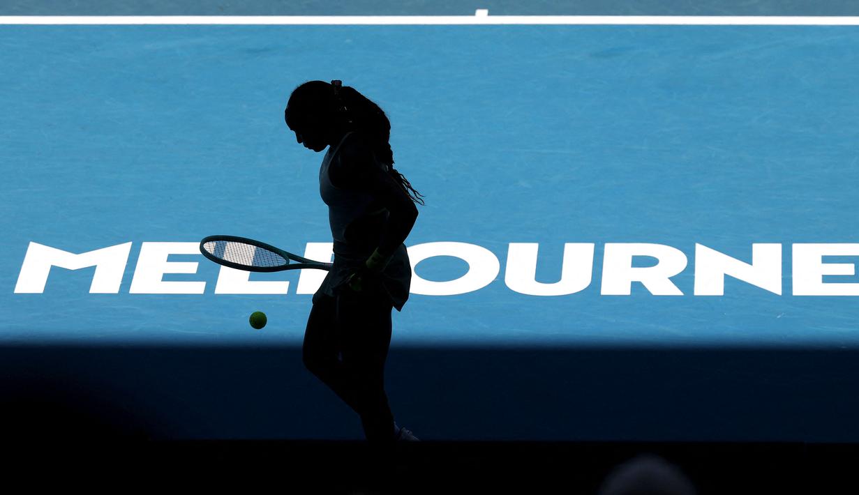 Siluet petenis Amerika Serikat, Coco Gauff saat bersiap melakukan servis ke arah kompatriotnya, Sofia Kenin pada hari kedua Australia Open 2025 di Melbourne, Australia, Senin (13/01/2025). (AFP/David Gray)