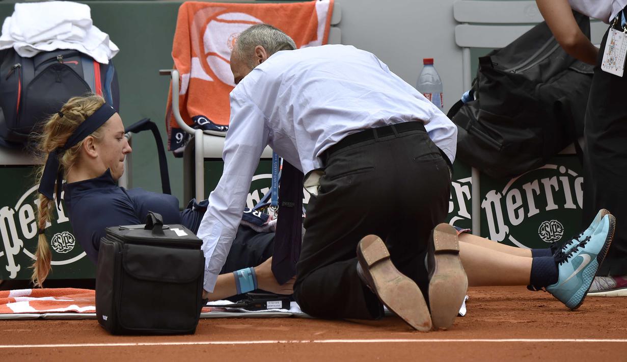 Victoria Azarenka menjalani perawatan oleh tim medis saat bertanding pada babak pertama Prancis Terbuka 2016 di Roland Garros, Paris, (24/5/2016). (AFP/Eric Feferberg)