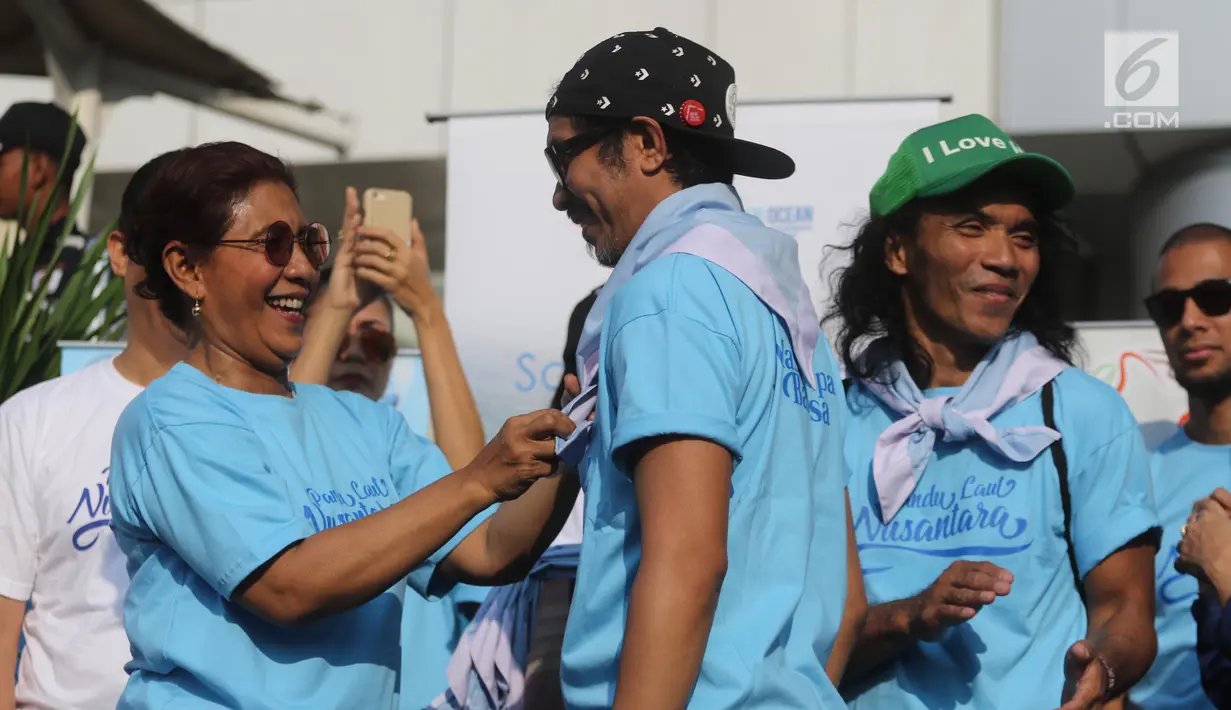 Menteri Kelautan dan Perikanan Susi Pudjiastuti memasangkan syal ke Ridho Slank saat meresmikan  'Pandu Laut Nusantara' sebagai wadah bersama untuk para pemerhati laut di CFD kawasan Bundaran HI, Jakarta, Minggu (15/7). (Liputan6.com/Arya Manggala)