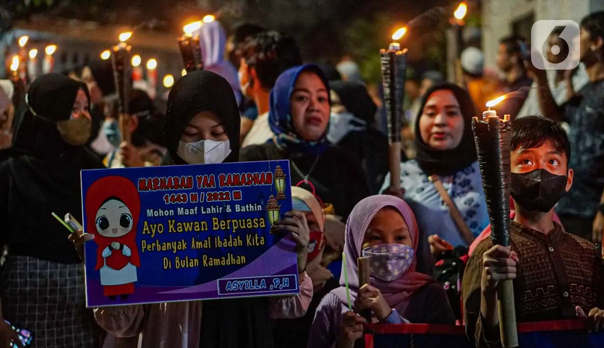 Warga mengikuti pawai obor menyambut Ramadan di kawasan Matraman Dalam, Jakarta, Minggu (27/3/2022). Pawai obor tersebut juga digelar untuk meningkatkan silaturahmi dan ukhuwah sesama umat Muslim serta menyemarakkan syiar Islam di Ibu Kota. (Liputan6.com/Faizal Fanani)