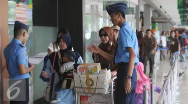 Petugas memeriksa kecocokan tiket calon penumpang pesawat di Bandara Halim Perdanakusuma Jakarta, Senin (4/7). H-2 jelang Idul Fitri 1437 H, ribuan calon penumpang diberangkatkan dari Bandara Halim Perdanakusuma. (Liputan6.com/Helmi Fithriansyah)