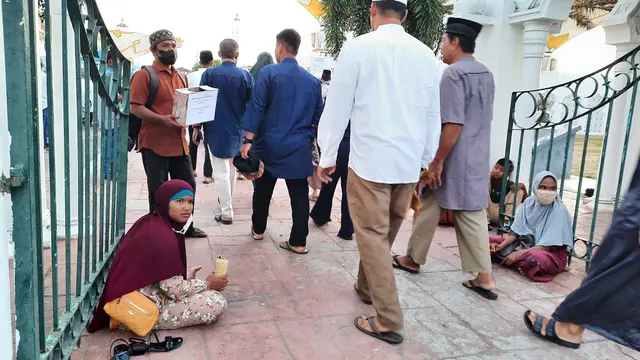 Pengemis menanti uluran tangan dari para jemaah salat Id Idulfitri 1443 H di Masjid Raya Baiturrahman (Liputan6.com/Rino Abonita)