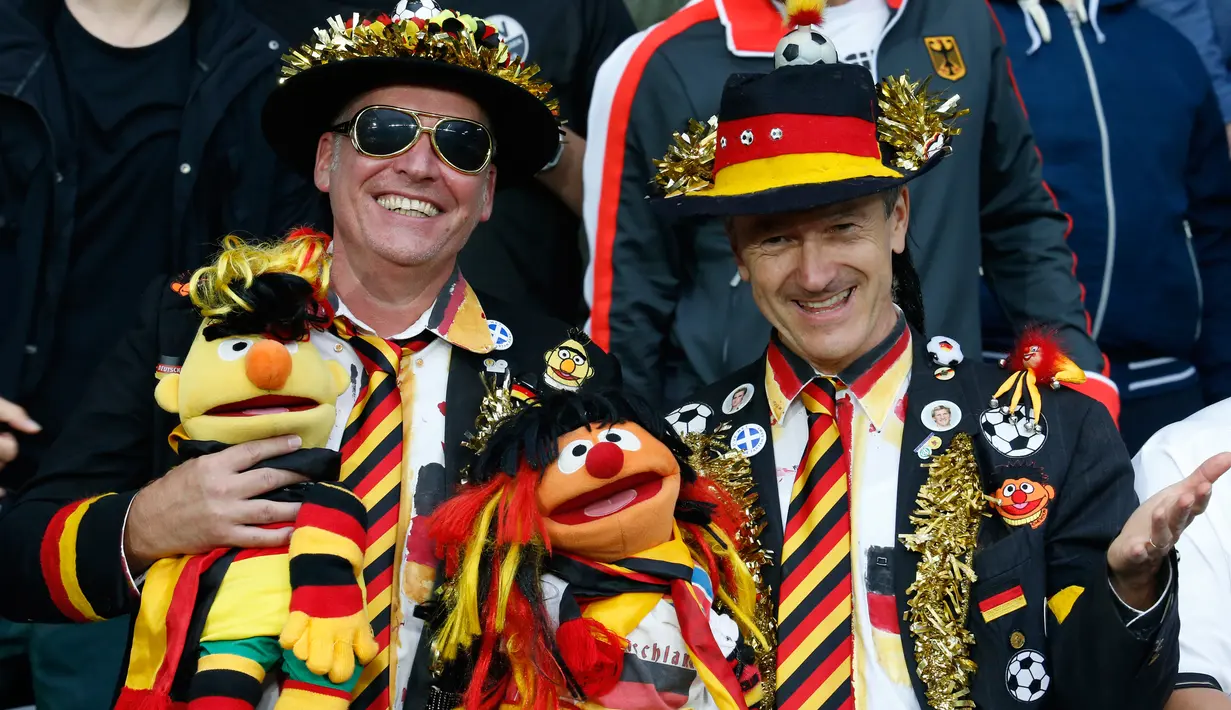 Dua Suporter Jerman menggunakan kostum unik sambil memegang boneka Sasame Street saat mendukung timnya melawan Ukraina pada pertandingan Grup C Euro 2016 di Stade Pierre-Mauroy, Lille, (12/6). (REUTERS/Pascal Rossignol)