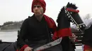 Seorang pemain cerita rakyat dari wilayah timur Iran menunggu perannya dalam upacara menjelang Tahun Baru Iran, atau Nowruz, di sebuah taman di Teheran, Iran (14/3/2022). (AP Photo/Vahid Salemi)