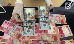 Karyawan menunjukkan uang dolar AS dan rupiah di Jakarta, Rabu (30/12/2020). Nilai tukar rupiah di pasar spot ditutup menguat 80 poin atau 0,57 persen ke level Rp 14.050 per dolar AS. (Liputan6.com/Johan Tallo)