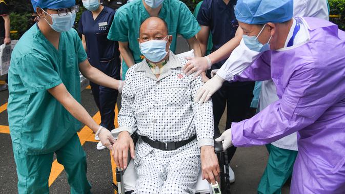 Petugas medis mendampingi Cui saat meninggalkan Rumah Sakit Renmin Universitas Wuhan di Wuhan, Provinsi Hubei, China (21/7/2020). Cui, seorang pasien COVID-19 yang menjalani operasi transplantasi paru-paru ganda, sembuh setelah perawatan selama berbulan-bulan dan dipulangkan. (Xinhua/Cheng Min)
