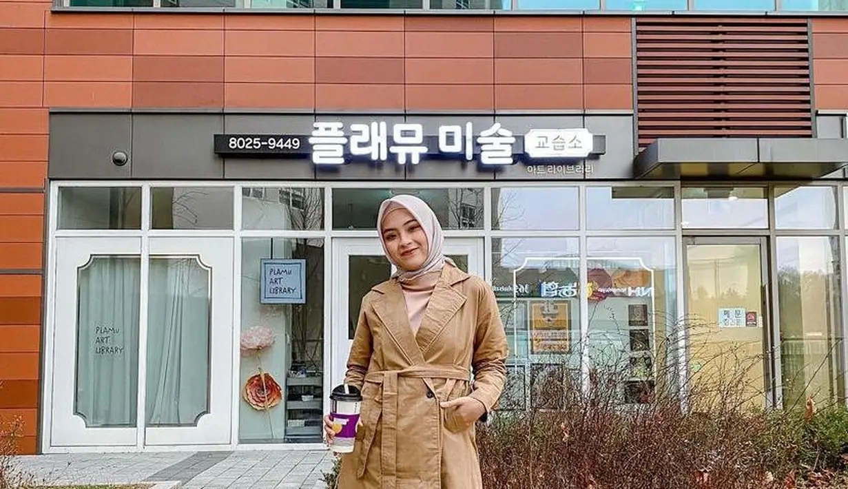 Gaya musim dingin, bisa tiru style digital creator Bianca Kartika satu ini. Padukan tunik model coat warna cokelat muda dengan rok plisket warna beige. Untuk hijab, kamu bisa pilih warna pastel seperti cream atau abu-abu muda (Instagram/biancakartika).