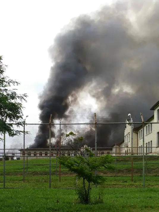 Asap hitam mengepul dari salah satu ruang tahanan Pusat Progresi Lembaga Pemasyarakatan di kota Bauru, barat laut Sao Paulo, Brasil, Selasa (24/1). Tak kurang dari 150 narapidana melarikan diri setelah kerusuhan yang memicu kebakaran. (STR/RECORD TV/AFP)