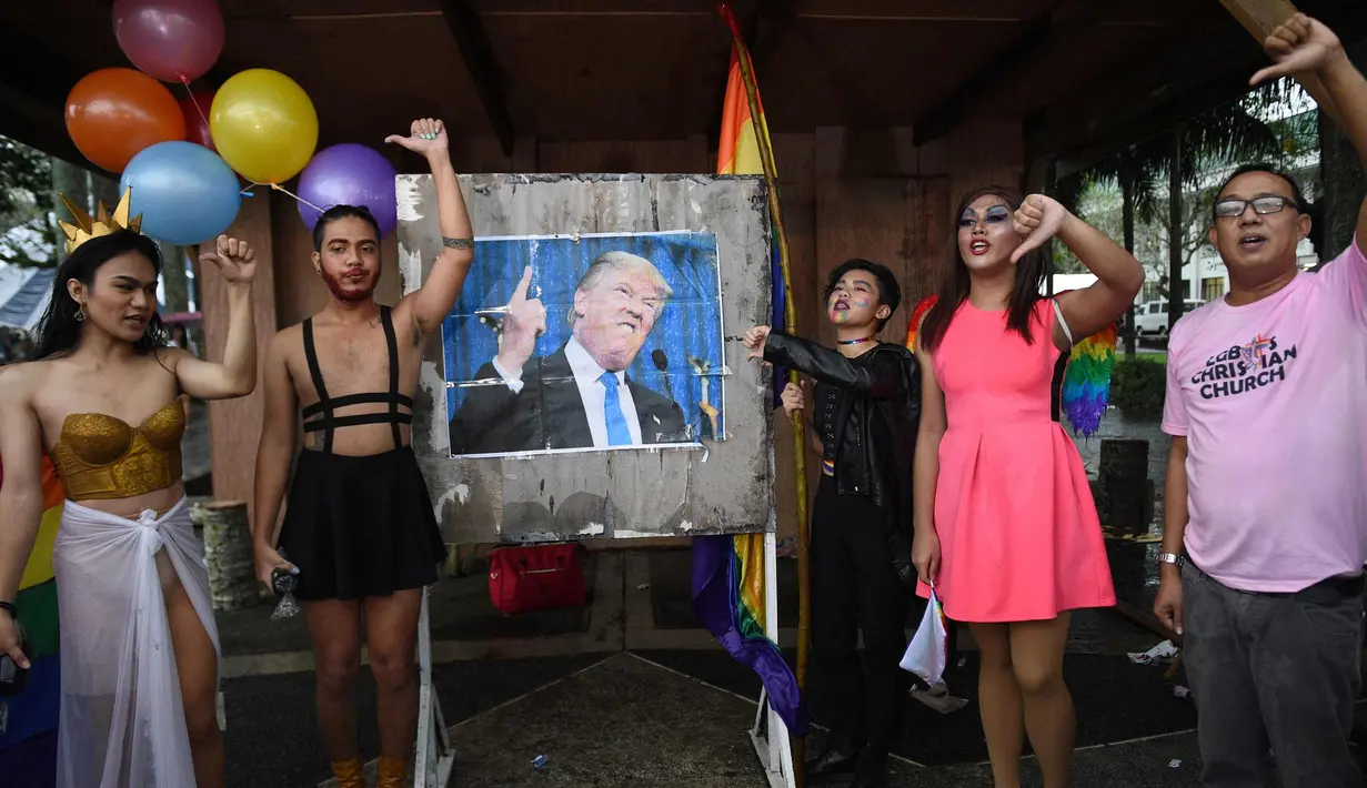 Kaum LGBT saat menggelar unjuk rasa menolak kedatangan Presiden AS Donald Trump saat demonstrasi di dalam kampus universitas negeri di kota Los Banos, provinsi Laguna, Manila, Filipina (9/11). (AFP Photo/Ted Aljibe)