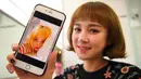 Personel girlband Six Bomb, Kim Da-Young atau Da-In, memperlihatkan foto dirinya sebelum menjalani operasi plastik di sebuah salon kecantikan di Seoul, Korsel, 16 Maret 2017. Da-In menjalani operasi plastik pada bagian atas tubuhnya. (YELIM LEE/AFP)