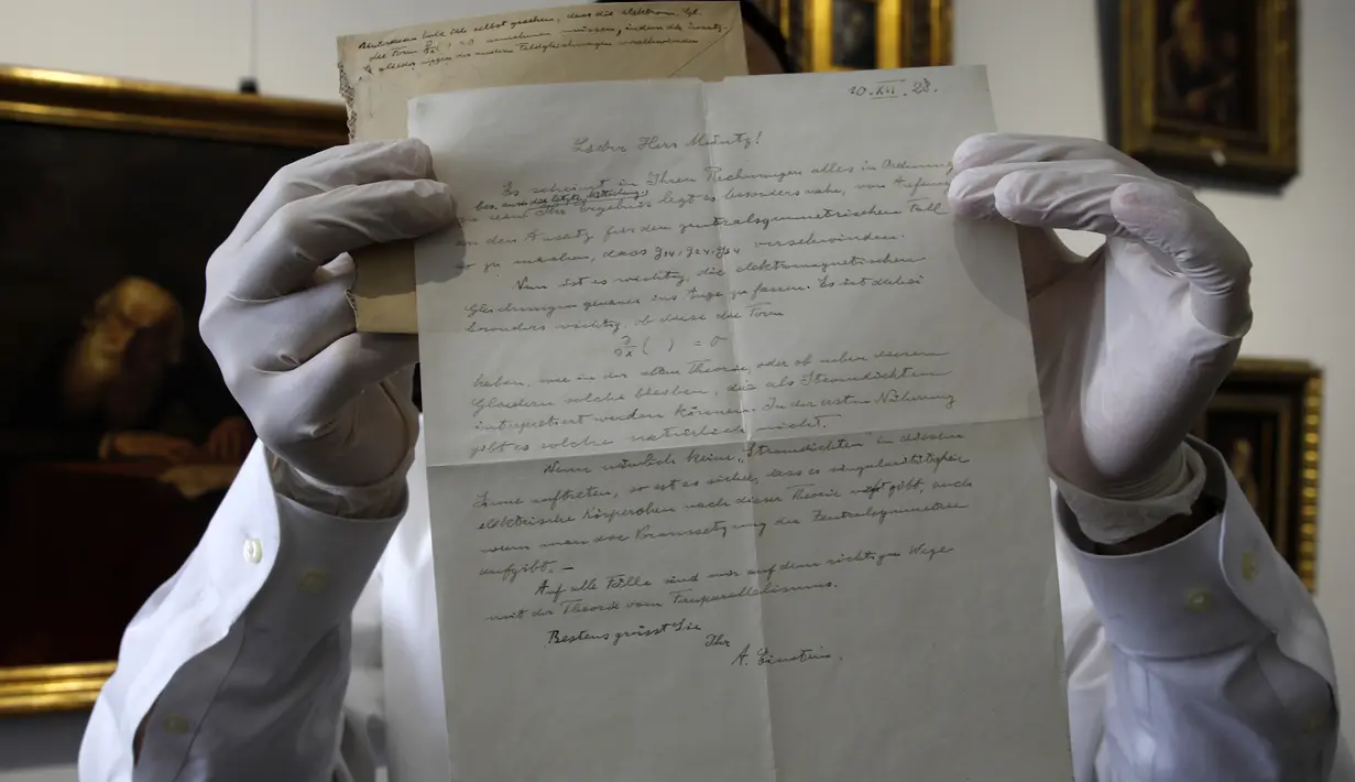 Petugas rumah lelang Winner menunjukkan surat rumusan "Tahap Ketiga Teori Relativitas" yang ditulis oleh Albert Einstein di Yerusalem, Selasa (6/3). Surat resmi tulisan tangan itu dikirim dari Berlin pada 1928 untuk ahli matematika. (MENAHEM KAHANA/AFP)