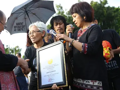 Jaya Suprana memberikan piagam kepada seorang wanita yang senantiasa melakukan Aksi Kamisan yang dilakukannya sejak tahun 2007, Jakarta, Kamis (19/1). (Liputan6.com/ Immanuel Antonius)