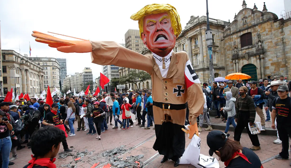Patung karakter Presiden AS Donald Trump disiapkan sebelum dibakar saat aksi protes pada peringatan Hari Buruh di Bogota, Kolombia (1/5). Ribuan orang di Kolombia turun ke jalan untuk memperingati Hari Buruh. (AP/Fernando Vergara)