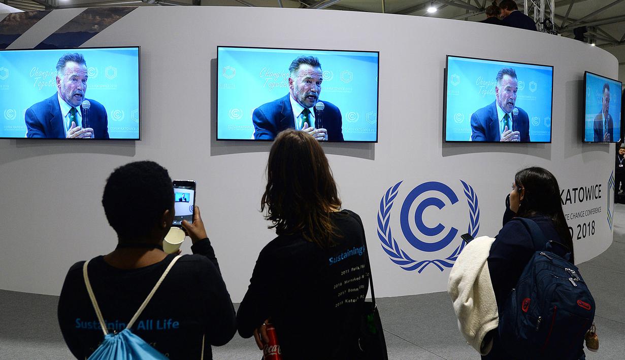 Pengunjung menonton pidato Arnold Schwarzenegger di Katowice, Polandia (3/12). Arnold Schwarzenegger membahas status dan pengendalian perubahan iklim global saat menjadi pembicara di forum tertinggi tersebut. (AP Photo/Czarek Sokolowski)