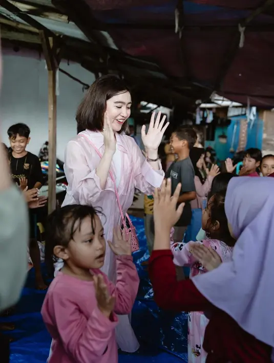 Ia tampil cantik mengenakan tank top putih yang serasi dengan celana panjangnya, ditumpuknya dengan long sheer shirt berwarna merah muda. [Foto: Instagram/febbyrastanty]