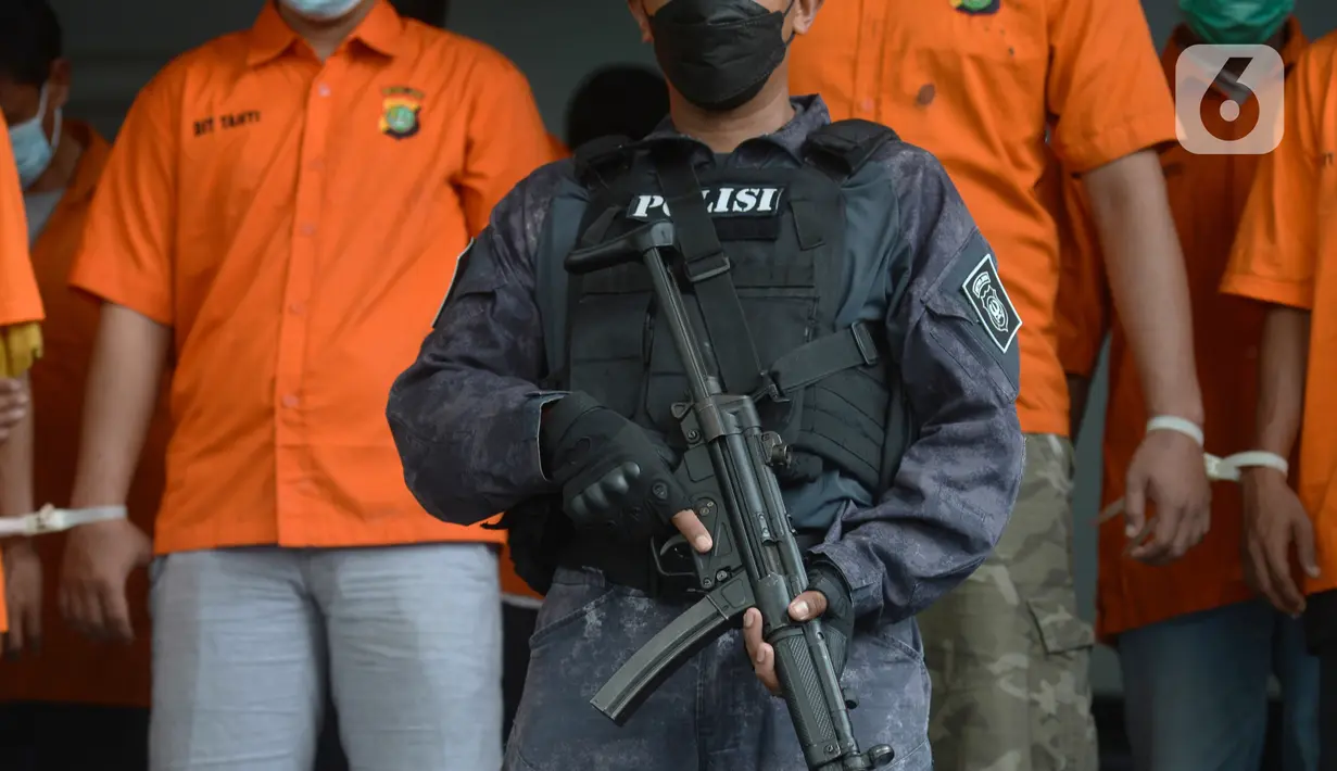 Polisi melakukan pengamanan saat rilis kasus pungli terhadap sopir truk kontainer Tanjung Priok di Polda Metro Jaya, Jakarta, Kamis (17/6/2021). Para preman pungli kepada ratusan sopir truk kontainer dengan total keuntungan Rp 177 juta. (merdeka.com/Imam Buhori)