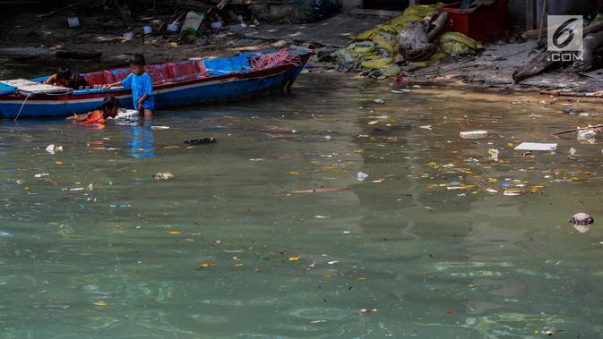 Anak-anak bermain di antara sampah kiriman yang mengotori perairan Kepulauan Seribu di sekitar Pulau Pari dan Pulau Pramuka, Rabu (28/11). Sampah berasal dari wilayah luar Jakarta yang terbawa angin hingga ke perairan Jakarta. (Liputan6.com/Faizal Fanani)