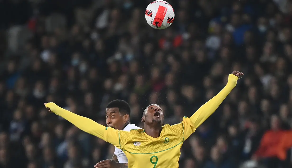 Bek Prancis Presnel Kimpembe (kiri) dan pemain depan Afrika Selatan Evidence Makgopa dalam laga persahabatan di Stadion Pierre Mauroy, Rabu (30/3/2022) dinihari WIB. Timnas Prancis berpesta lima gol ke gawang Afrika Selatan. (FRANCK FIFE / AFP)